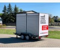 Mobilna kotłownia na olej opałowy 100 kW. Zdjęcie przedstawia przyczepę z zamkniętymi roletkami.